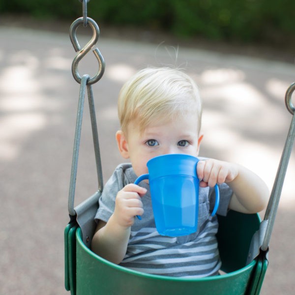 Baby sitting in swing drinking from cheers360