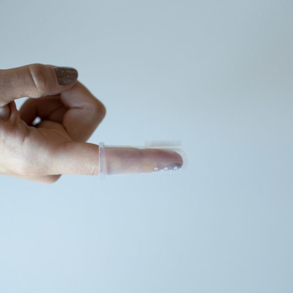 Close up image of hang with finger toothbrush on index finger